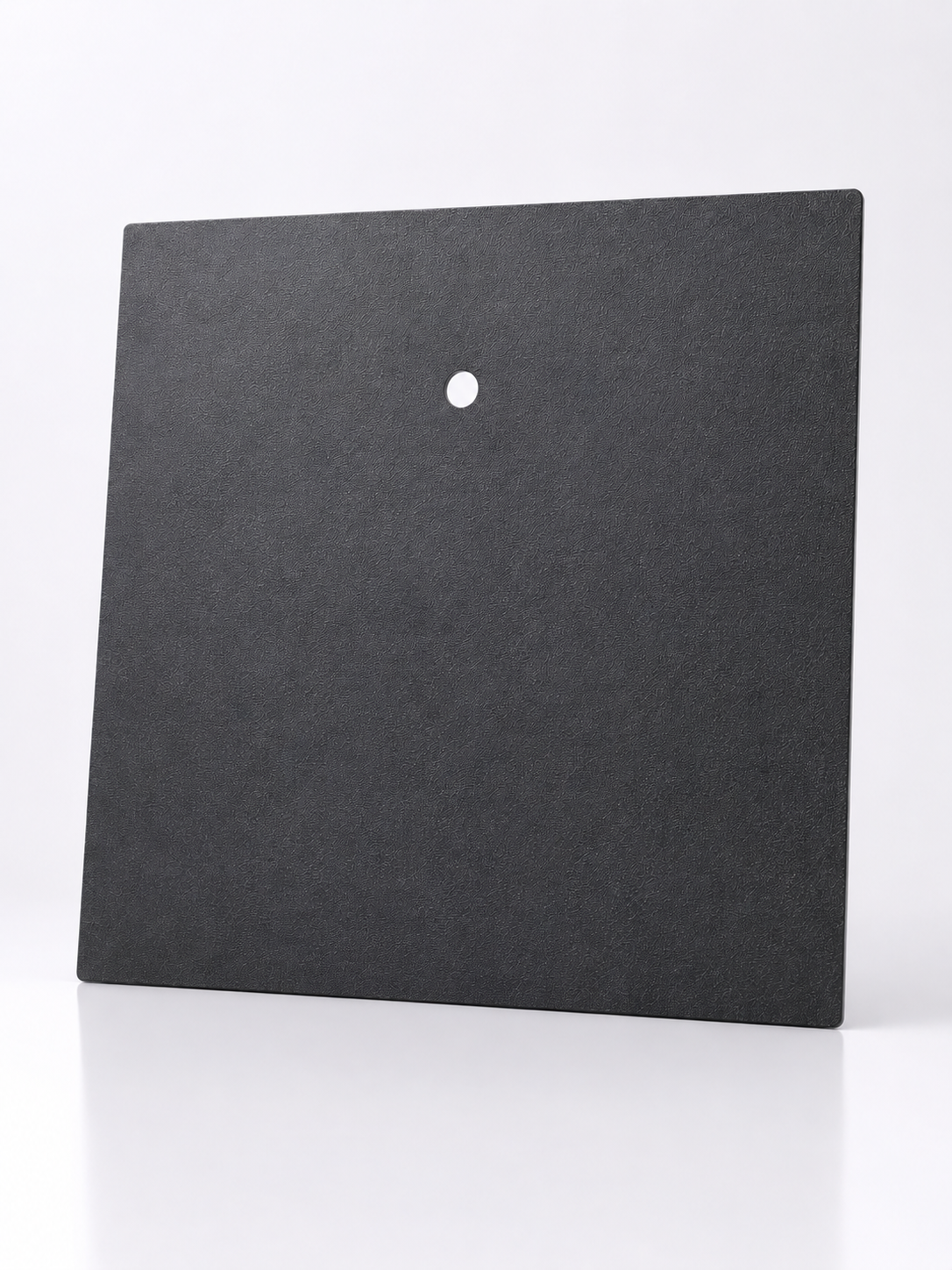 Black square tile with a central hole on a white background
