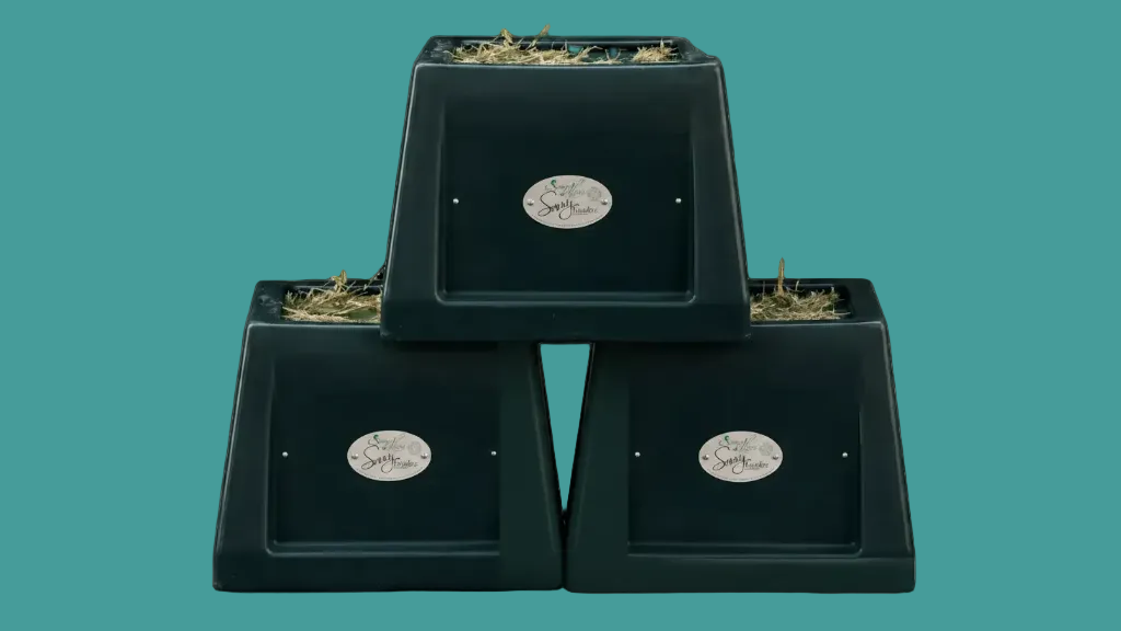 Three black square containers stacked on a teal background